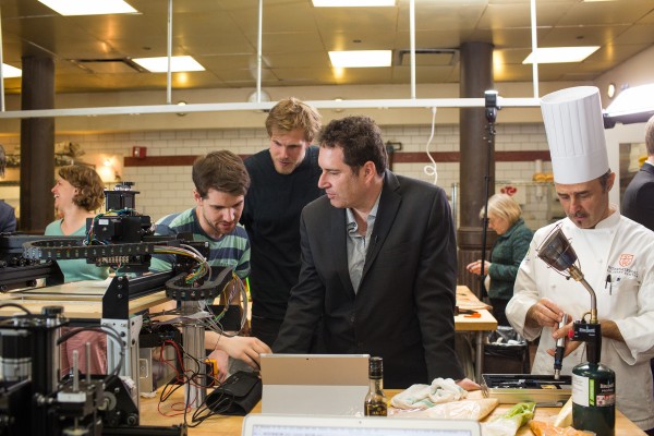 PhD student Joni Mici, grad student Drim Stokhuijzen, Columbia Engineering Professor Hod Lipson, and ICC Chef Hervé Malivert working on 3D food printer. (Photo: Timothy Lee Photographers/Columbia Engineering)