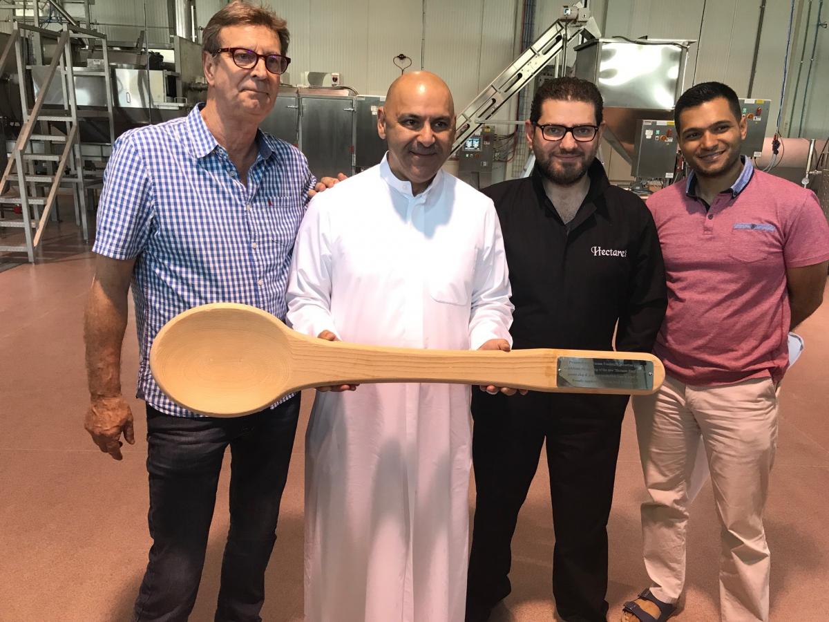 Fabcon's Trevor Howard presents a special wooden spoon to Muntaser AlWazzan and colleagues