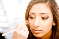 Indian woman applying makeup